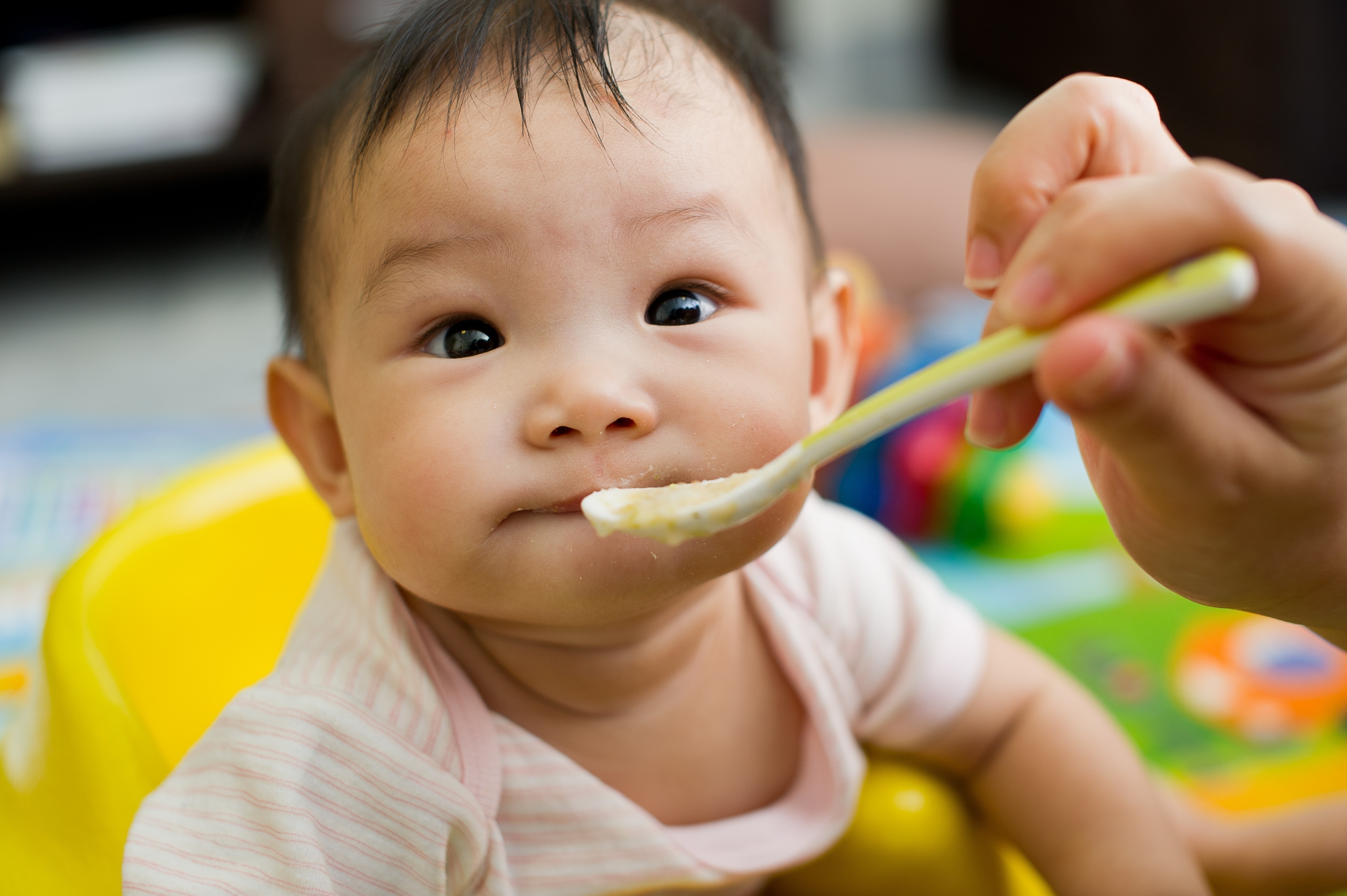 Spoon feeding a cute baby